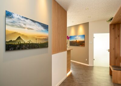 Heller, moderner Wartebereich einer Arztpraxis mit Holzelementen und Orchidee.